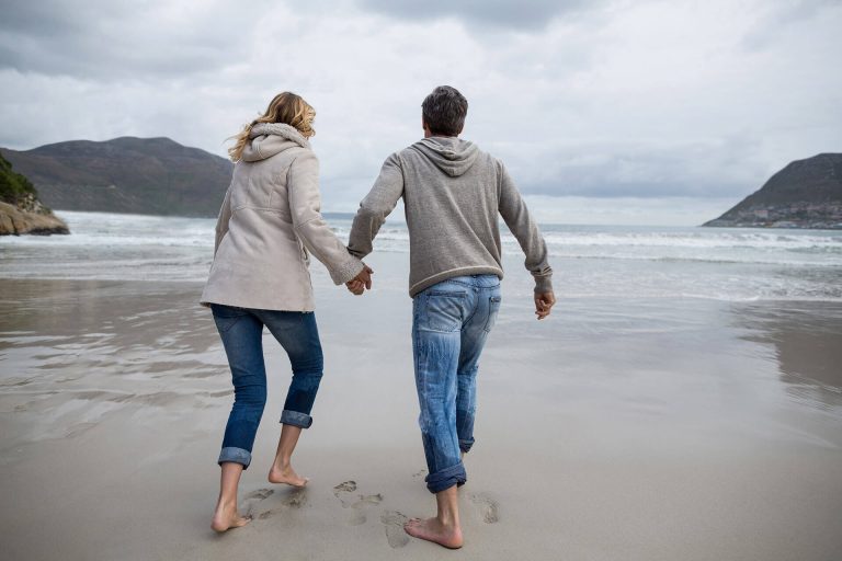 mature-couple-running-on-the-beach-P9CC9KL-1-1-768x512